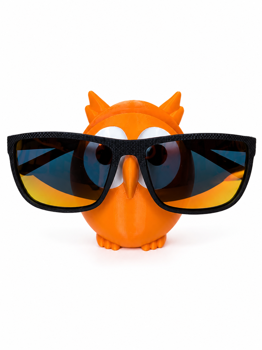 Orange owl figurine wearing large black sunglasses on a white background