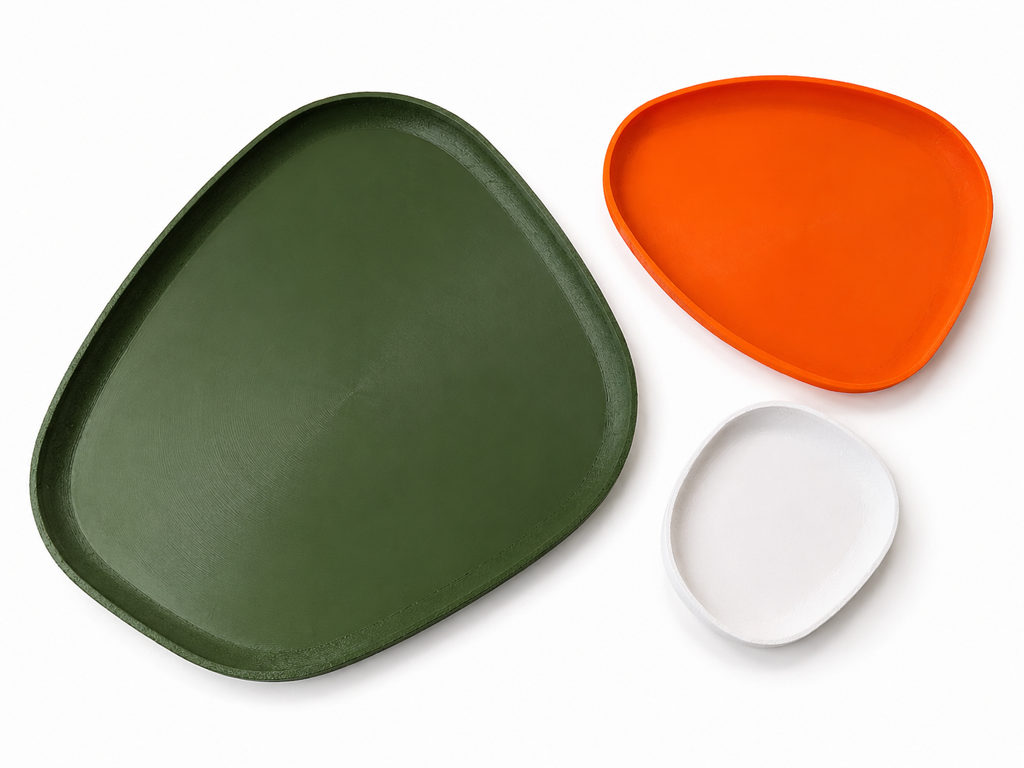 Three colorful trays in green, orange, and white on a white background